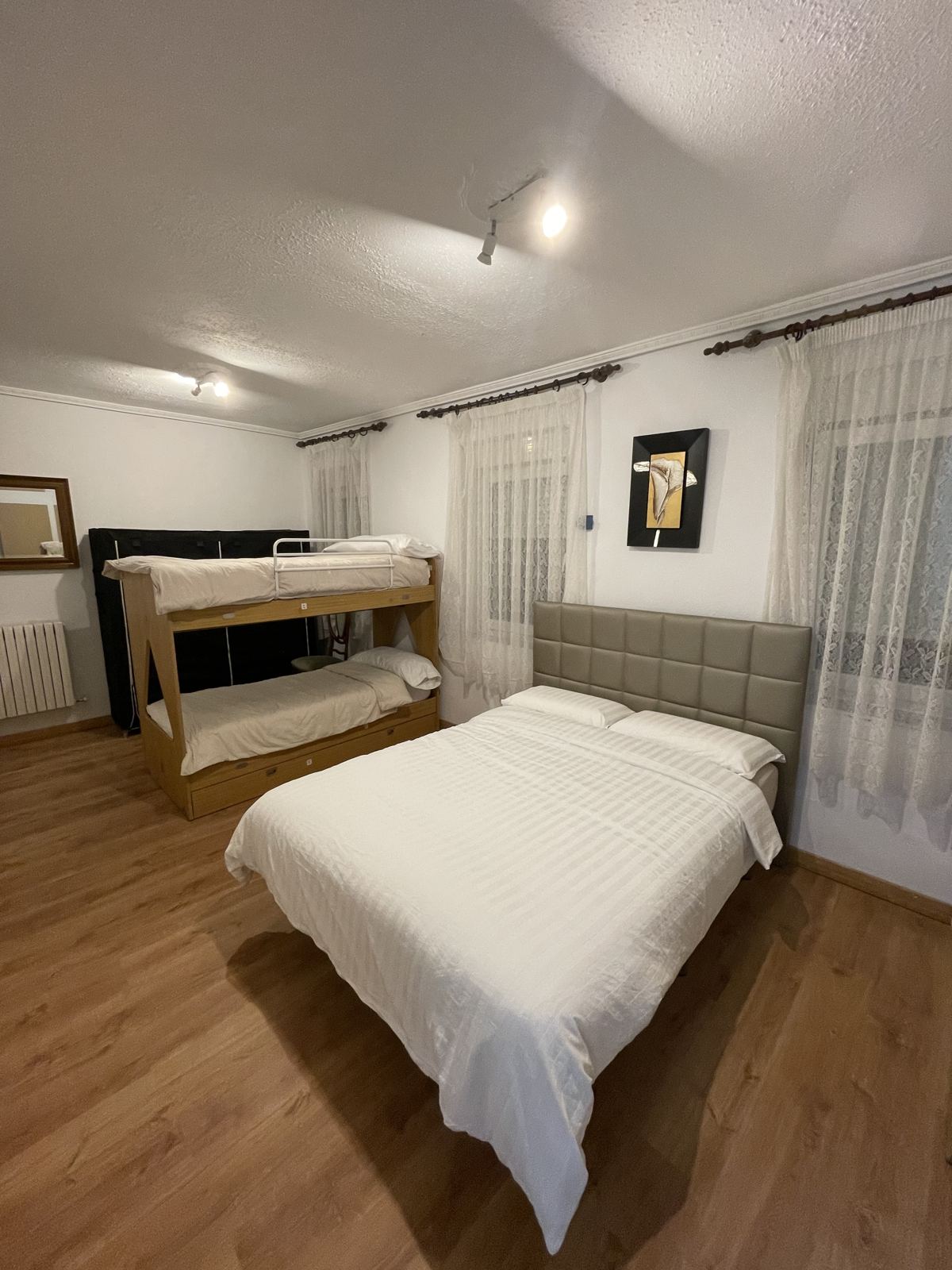 Dormitorio con cama de matrimonio y literas